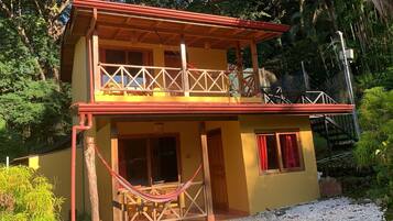 A two-story building with a balcony, wooden railings, and a red roof.