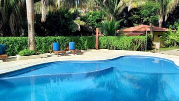 Relax by the serene pool surrounded by lush tropical vegetation and lounge in style on the poolside chairs.