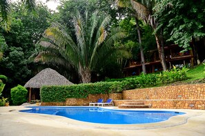 Alberca al aire libre y camastros 