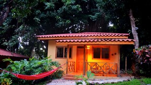 Un petit bâtiment d’un seul étage, avec un toit recouvert de tuiles rouges et une véranda en bois.