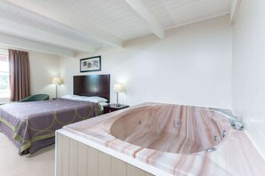 A hotel room with two beds, a large bathtub, and a nightstand with lamps. - Super 8 by Wyndham Beaver Falls (Beaver Falls)