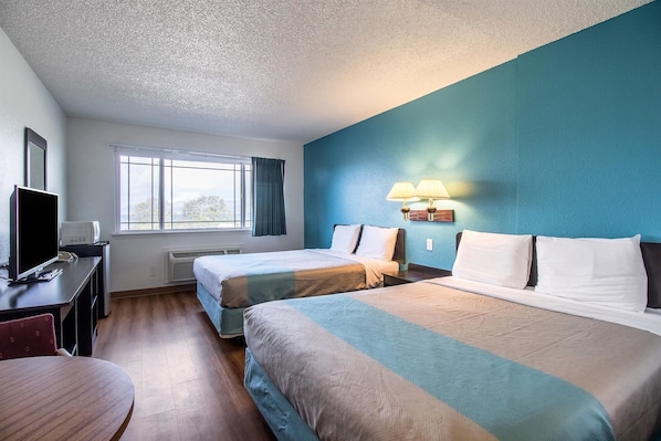 A hotel room with two beds, a desk with a TV, and a window with curtains. - Motel 6 Astoria, OR (Astoria)