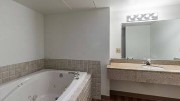 A bathroom with a bathtub, a sink, and a mirror.
