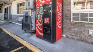 A Coca-Cola vending machine next to a building with a stone facade and a window. - Motel 6 Astoria, OR (Astoria)