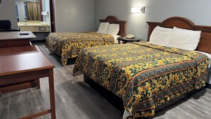 A hotel room with two beds, a desk, and a mirror. - Claremore Motor Inn (Claremore)