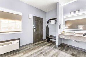 A modern bathroom with a large mirror, a sink, and a shower area.