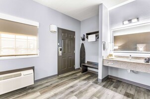Un baño moderno con un espejo grande, un lavabo y una zona de ducha.