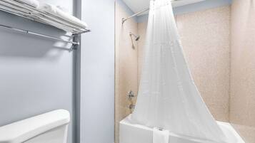 A shower area with a bathtub, a towel rack, and a shower curtain.