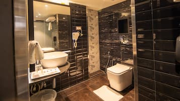 Ein modernes Badezimmer mit einem großen Waschbecken, einer Toilette, einer Dusche und einem Föhn.