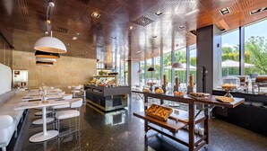 A modern restaurant with a polished marble floor, white furniture, and a central serving area with food displays.
