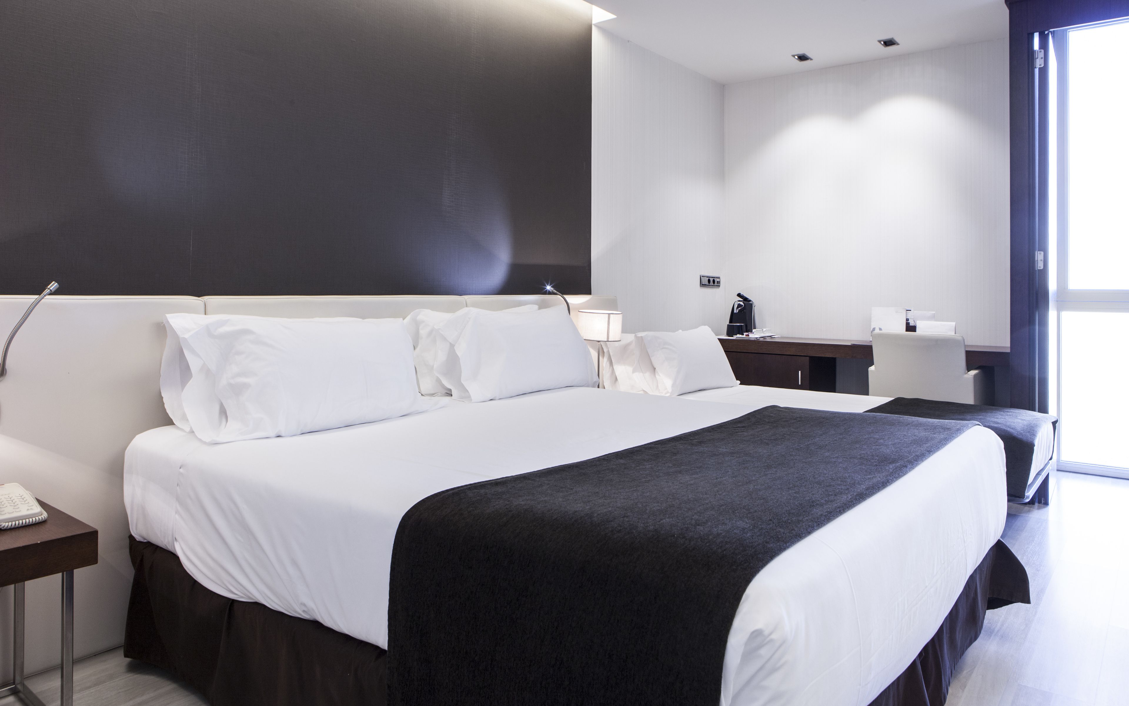 Une chambre d’hôtel moderne avec un grand lit, un bureau et une fenêtre.