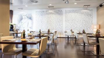 Een restaurant met gedekte tafels, een grote muur met tekst en een modern interieur.