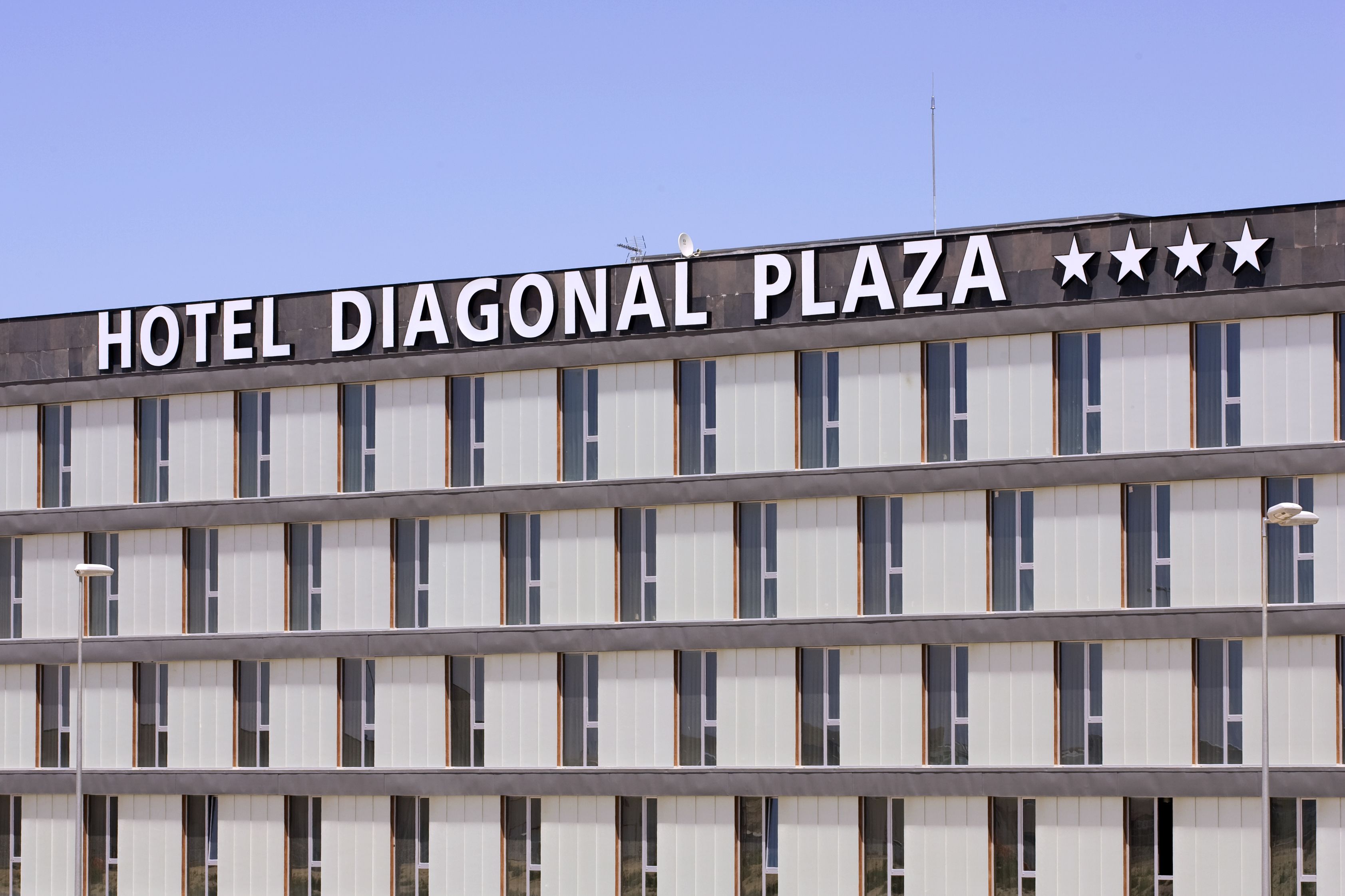Un edificio con el letrero "HOTEL DIAGONAL PLAZA" y cinco estrellas.