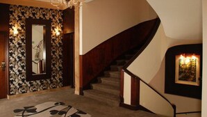 A grand staircase with a dark wooden finish and a beige carpet. - Hotel Napoleon (Buenos Aires)