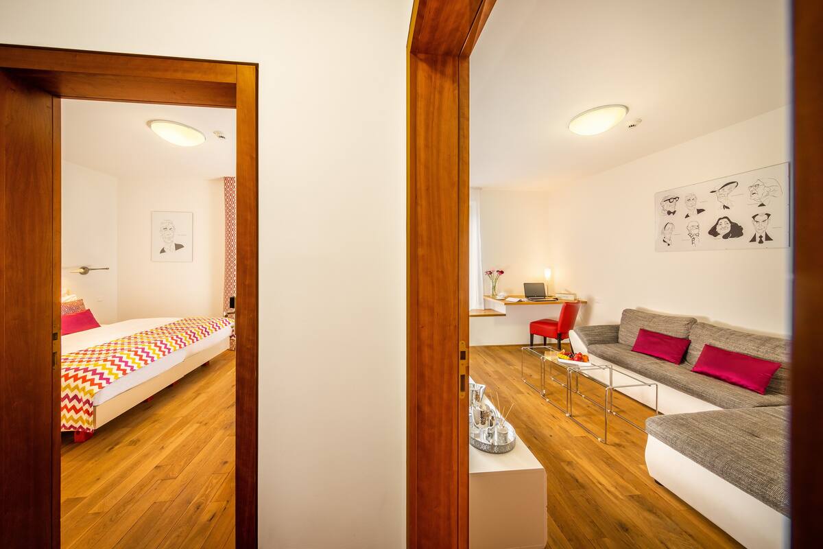 Una habitación moderna con una cama, un sofá, un escritorio y una silla.