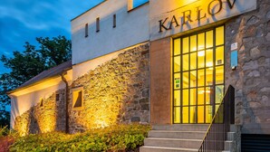 Un edificio con fachada de piedra y una amplia entrada de vidrio con la leyenda 