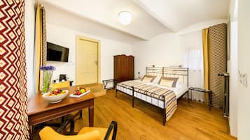 A bedroom with a bed, bedside table, and a desk with a chair.