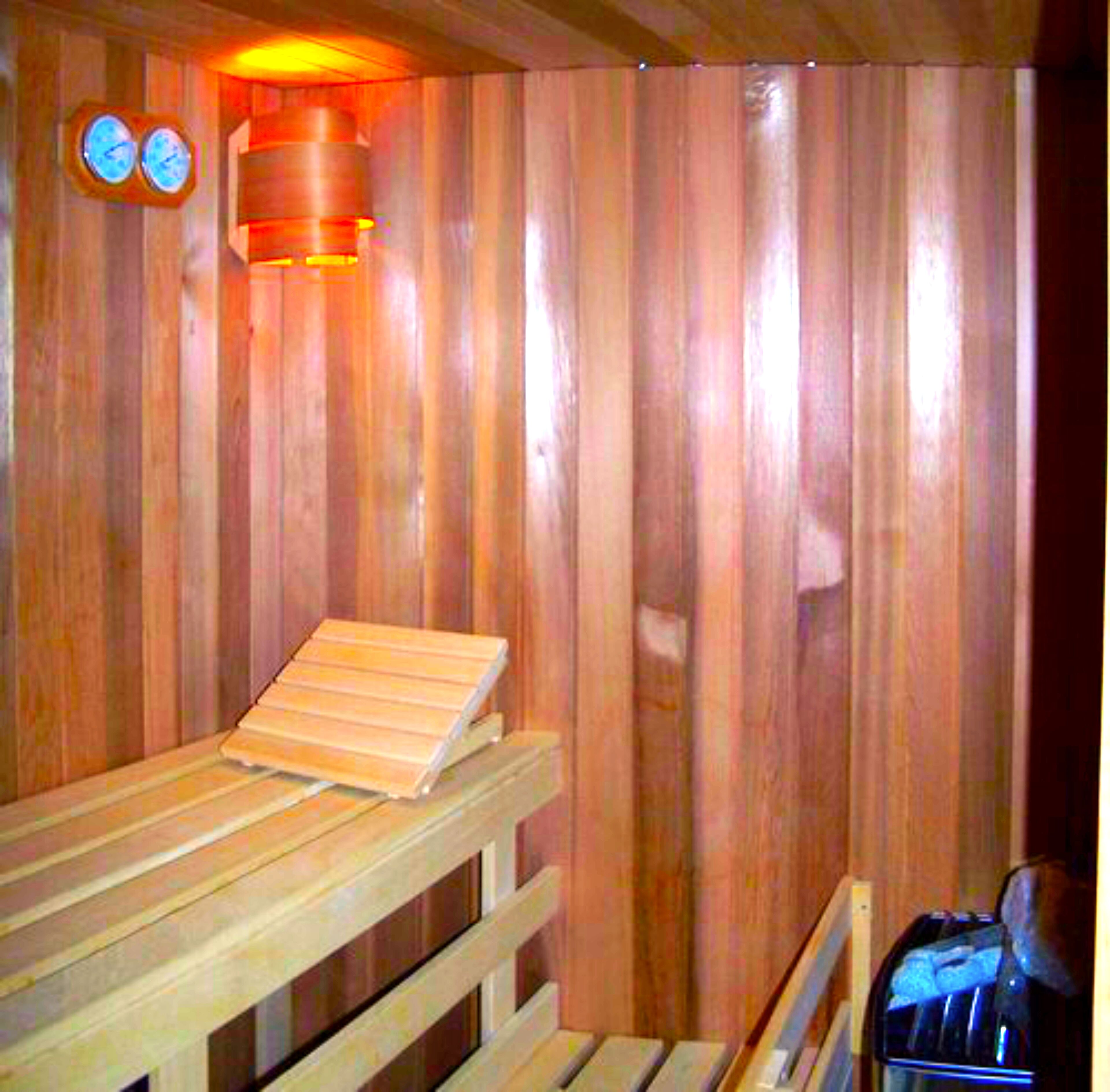 A wooden sauna with a bench and a heater.