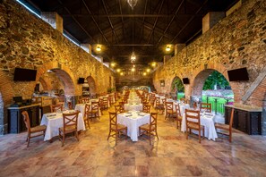 A spacious dining area with brick walls, multiple tables, and chairs. - Fiesta Americana Hacienda San Antonio el Puente Resort & Spa (Xochitepec)