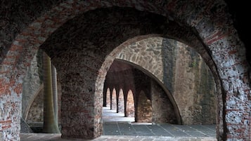 Un interior con arcos de piedra y suelo de baldosas.