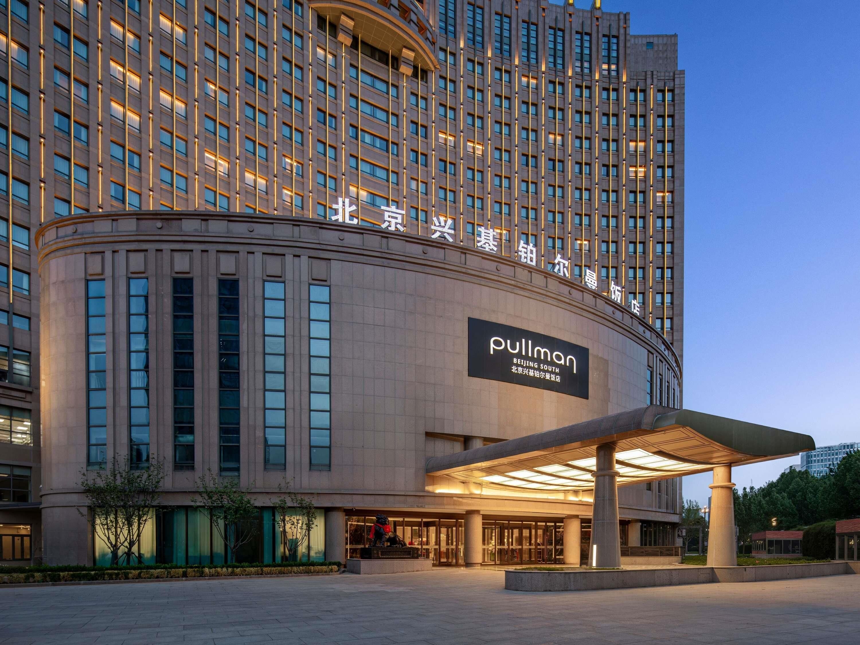 A high-rise hotel with a prominent entrance, large windows, and a sign for Pullman Beijing South.