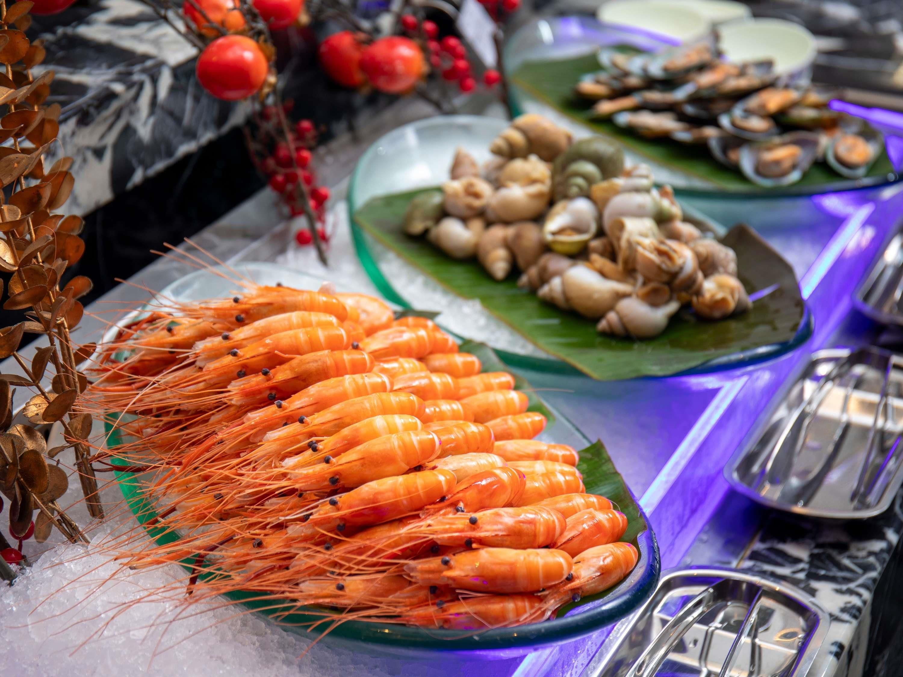 A buffet with seafood, including shrimp, clams, and oysters.