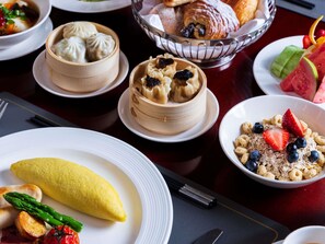 A variety of dishes including dumplings, a croissant, and a bowl of cereal with fruit.