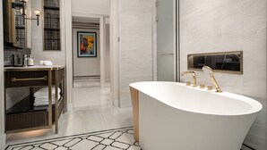 Une salle de bain moderne avec une baignoire sur pieds, un meuble-lavabo avec un miroir et un porte-serviettes.