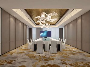 A modern conference room with a large flat-screen TV, white chairs, a central table, and a patterned carpet. - Pullman Beijing South - Newly Renovated (Beijing)