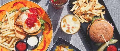 A variety of food items including a burger, fries, and a plate with a fish sandwich.