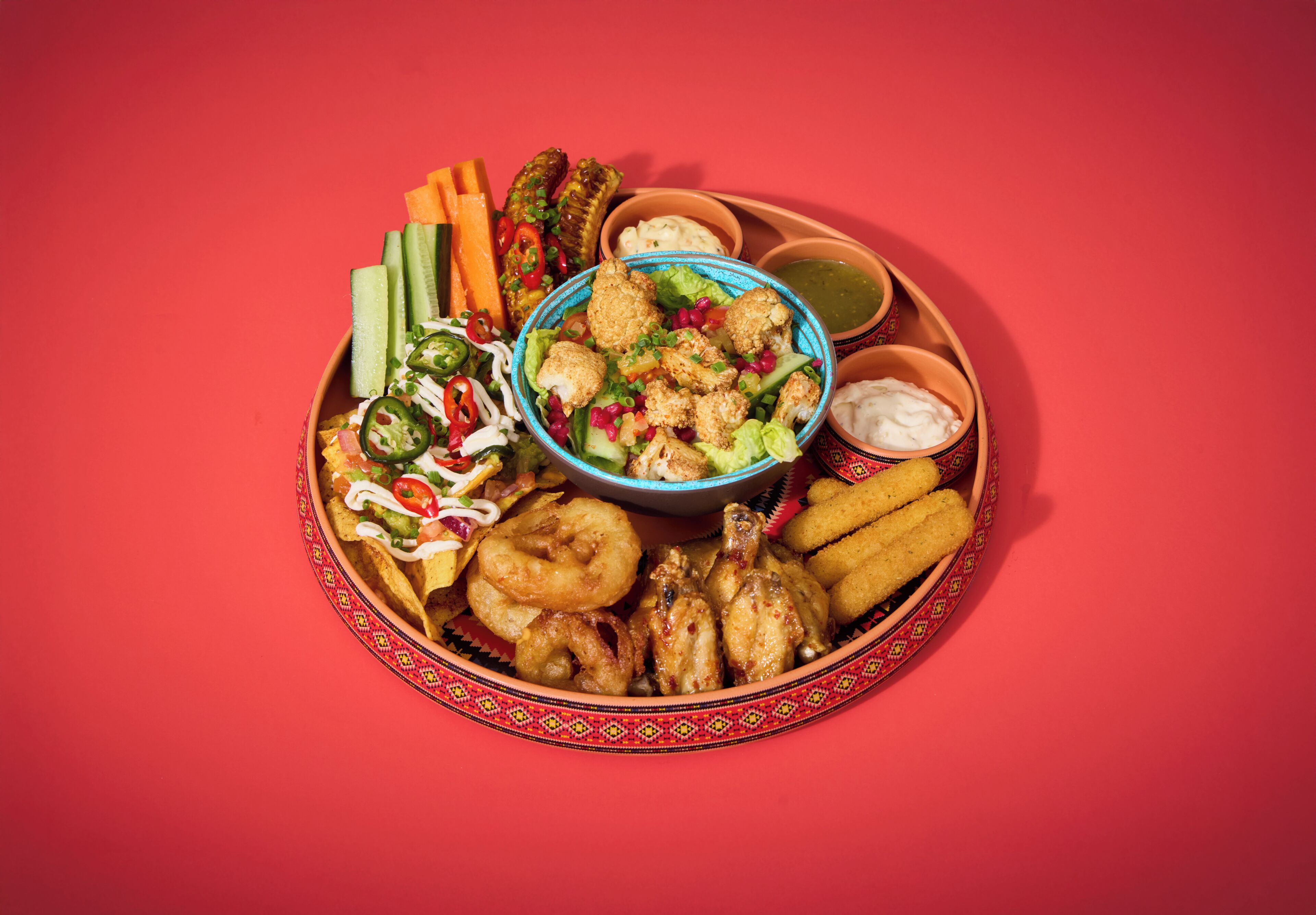 Un plato de nachos con diversos ingredientes y acompañamientos.