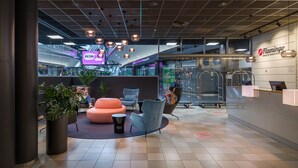 A modern hotel lobby with seating areas, a reception desk, and a view of the interior space. - Break Sokos Hotel Flamingo (Vantaa)