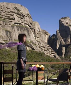 A person standing on a balcony with a view of a rocky landscape. - Dellas Boutique Hotel (Kalabaka)