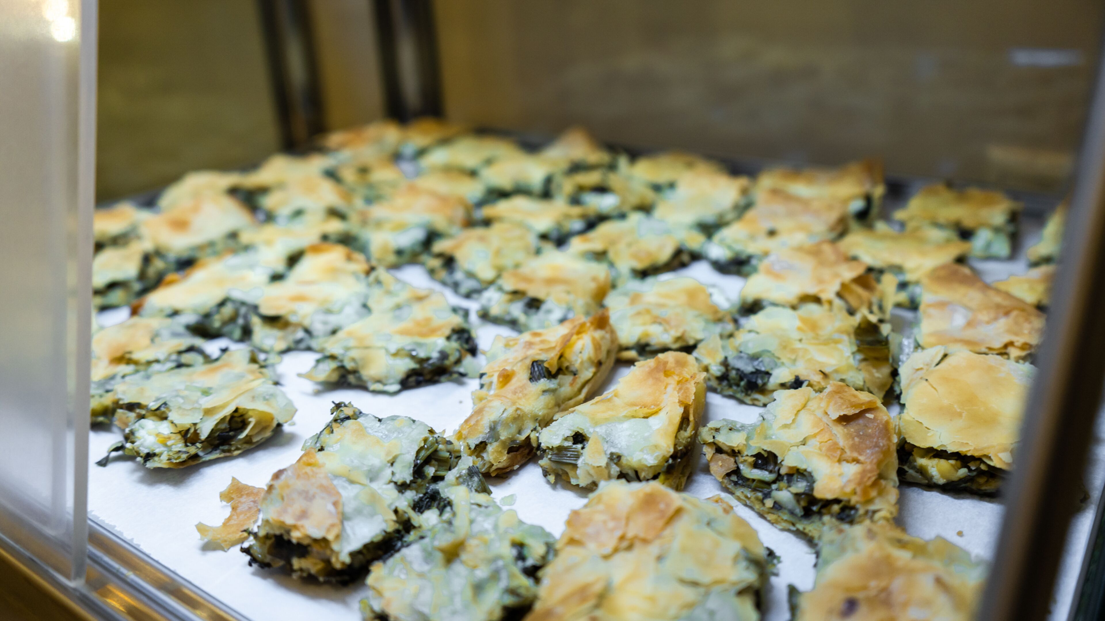 A display of baked pastries in a glass case.
