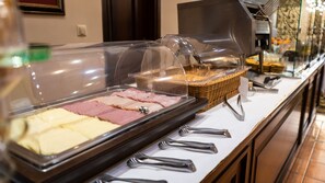 A buffet with various food items and utensils. - Dellas Boutique Hotel (Kalabaka)
