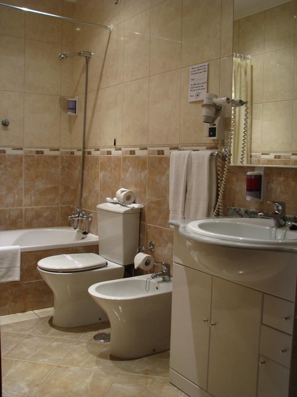 Un bagno con una vasca, un water, un bidet e un lavandino.