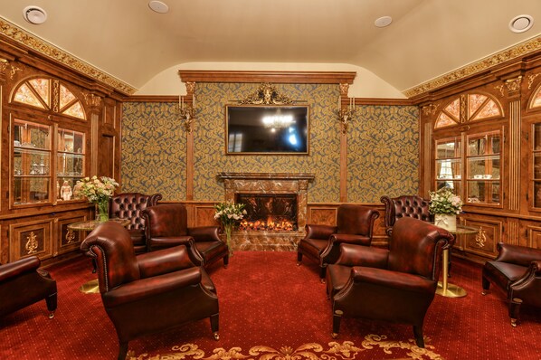 A luxurious room with a fireplace, leather armchairs, and a large mirror. - Hotel Hastal Prague Old Town (Prague)