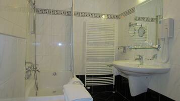 A bathroom with a bathtub, a shower, a sink, and a toilet.