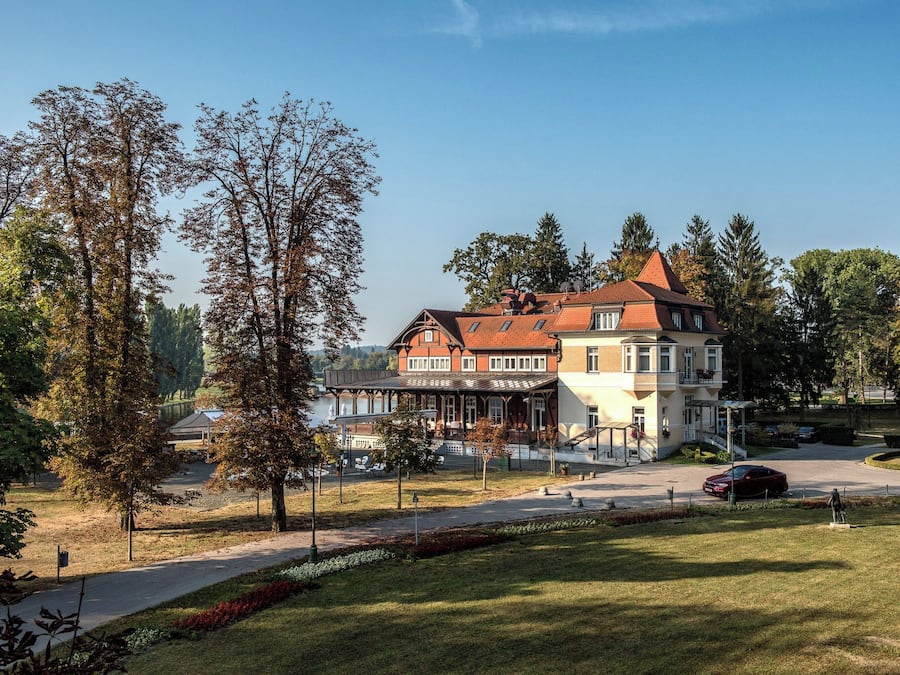 Ein großes, mehrstöckiges Gebäude im traditionellen Stil, mit einem markanten Eingangsbereich und einem begrünten Innenhof.