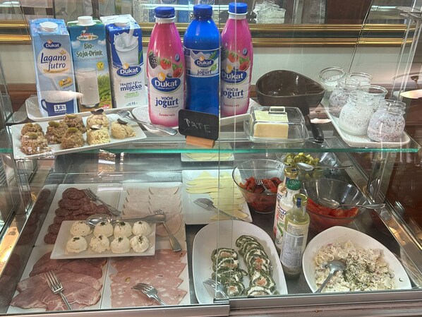 Variedad de productos lácteos, como yogures y zumos, en una vitrina refrigerada.