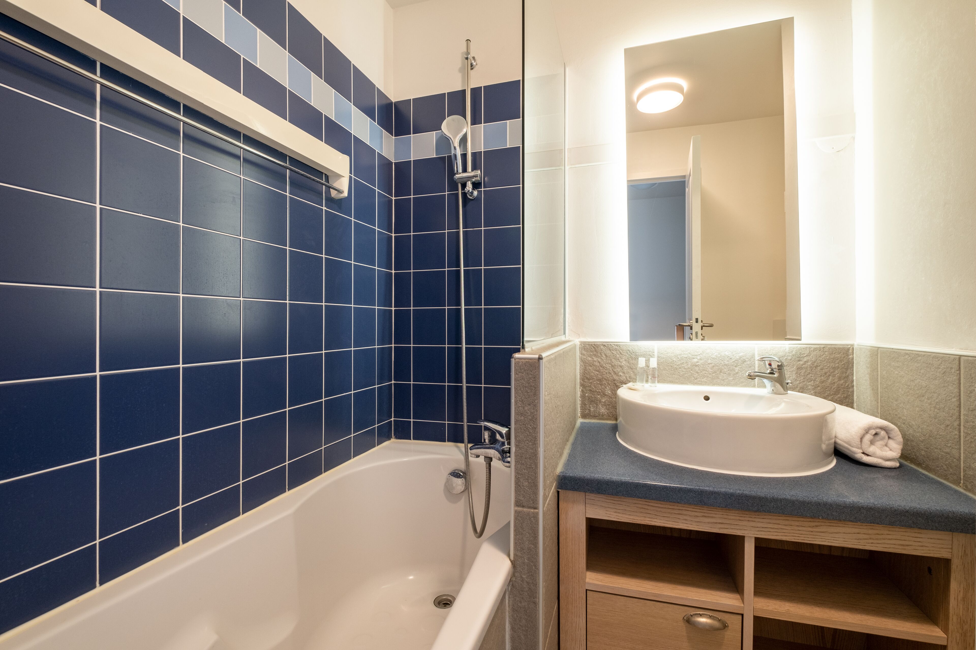 A bathroom with a bathtub, a sink, and a mirror.