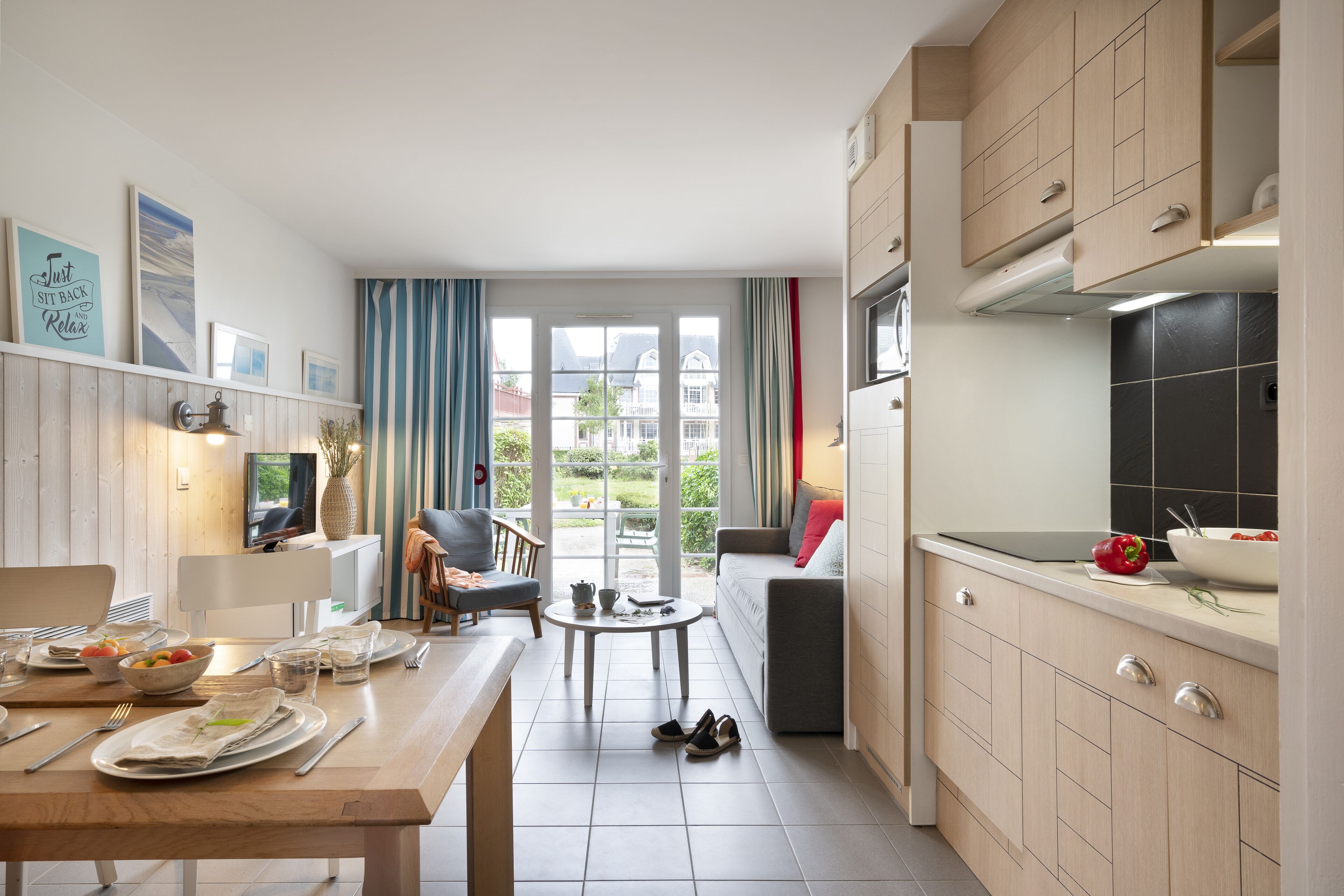 Une cuisine moderne avec un coin repas, de grandes fenêtres et une vue sur les bâtiments environnants.
