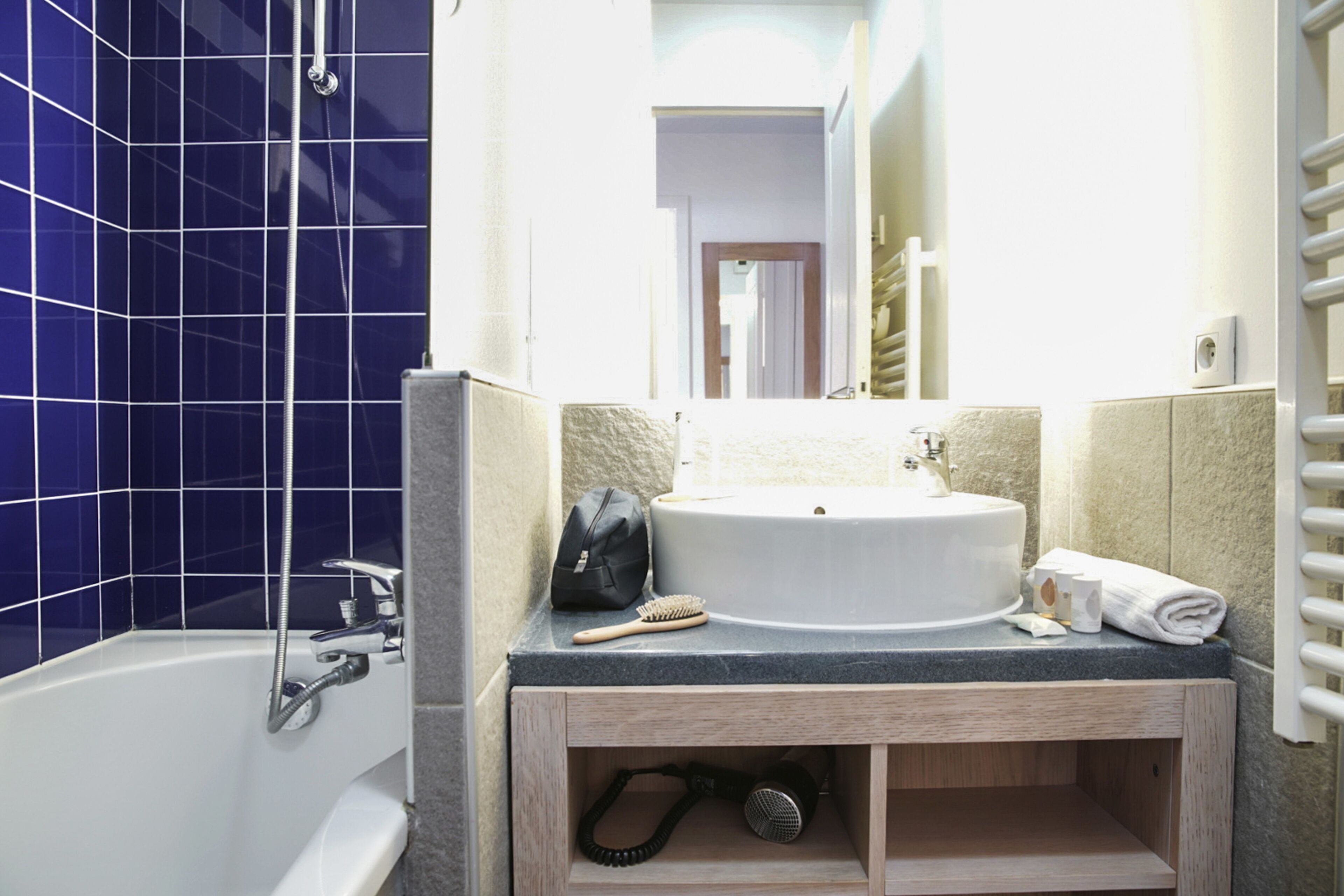 A bathroom with a bathtub, a sink, and a mirror.