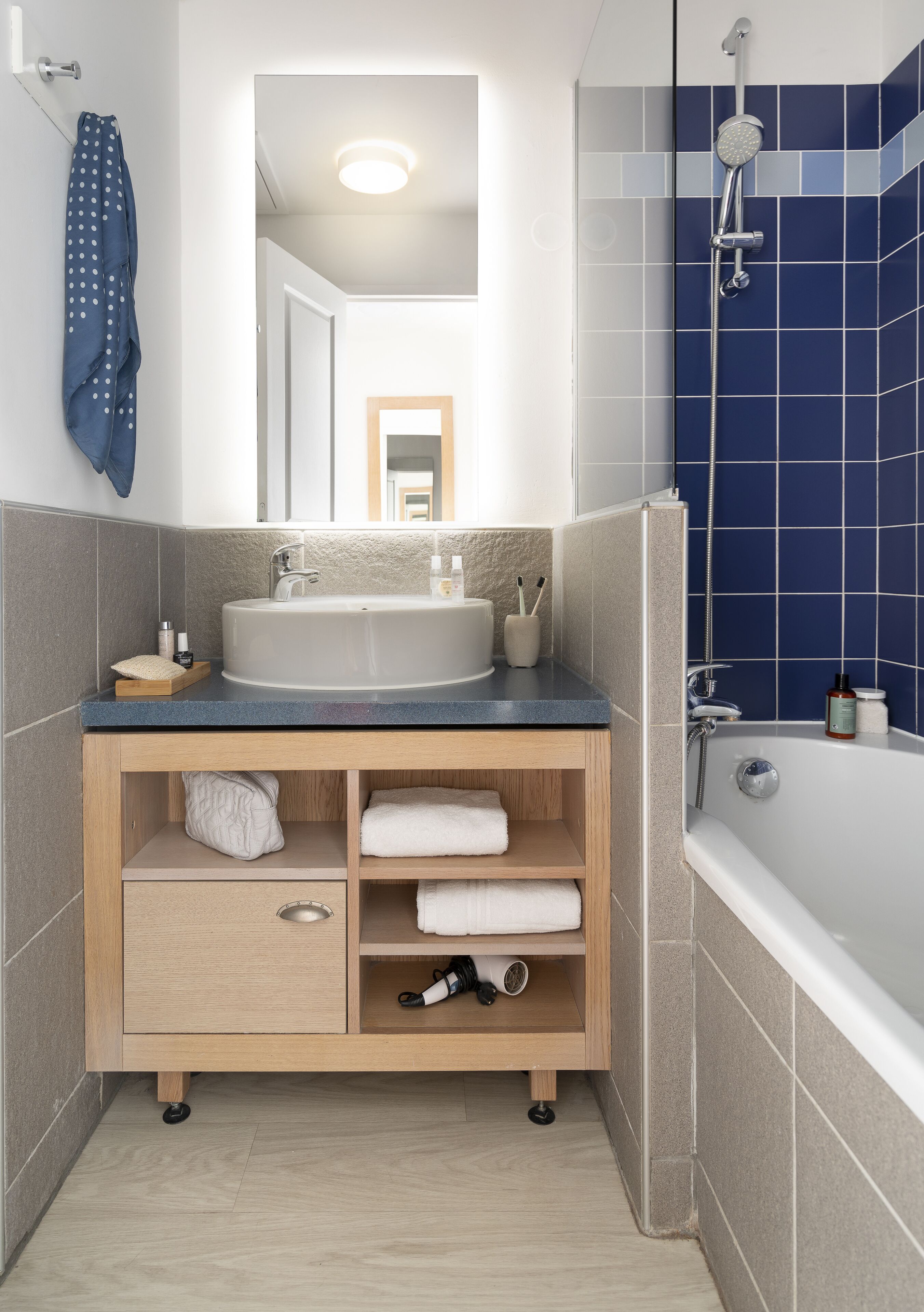 Een moderne badkamer met een vrijstaand bad, een wastafel met spiegel erboven en een handdoekhouder.