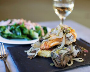 A plate of food with a glass of white wine. - Appellation Lodi - Wine & Roses Resort & Spa (Lodi)