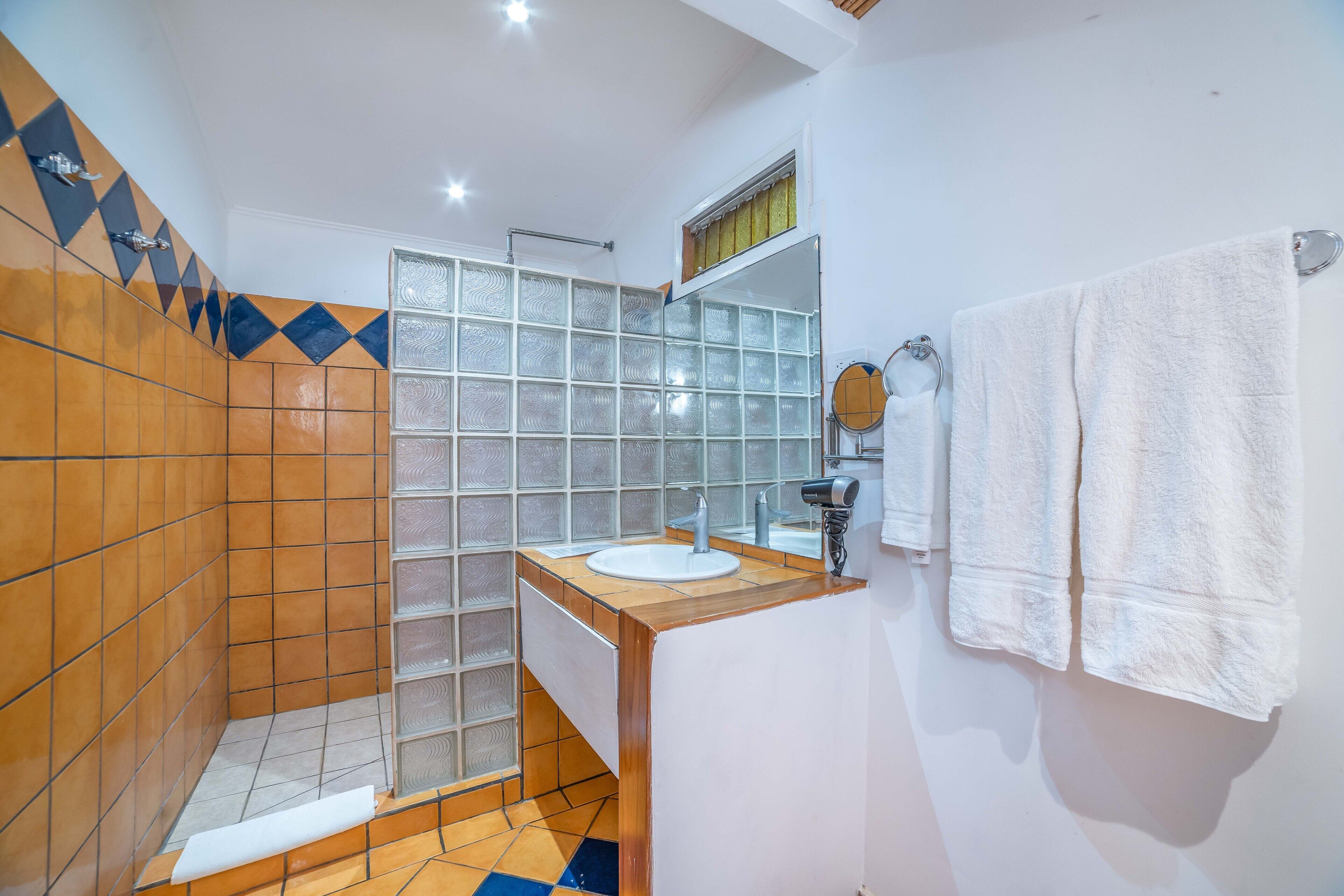 family deluxe  room 2 queens beds | bathroom | shower, rainfall showerhead, free toiletries, towels