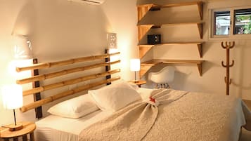 Uma cama com cabeceira de madeira, abajur e mesa de cabeceira.