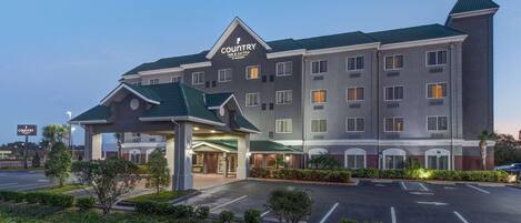 A Country Inn & Suites with a central entrance, multiple floors, and a parking lot.