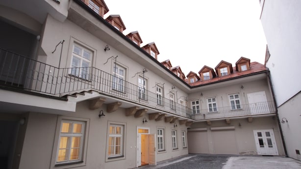 A building with a courtyard, multiple balconies, and a red-tiled roof. - Prague Central Residence (Prague)