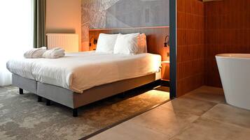 Een moderne hotelkamer met een groot bed, een badkamer met bad en een stadsgezicht muurschildering op de muur.